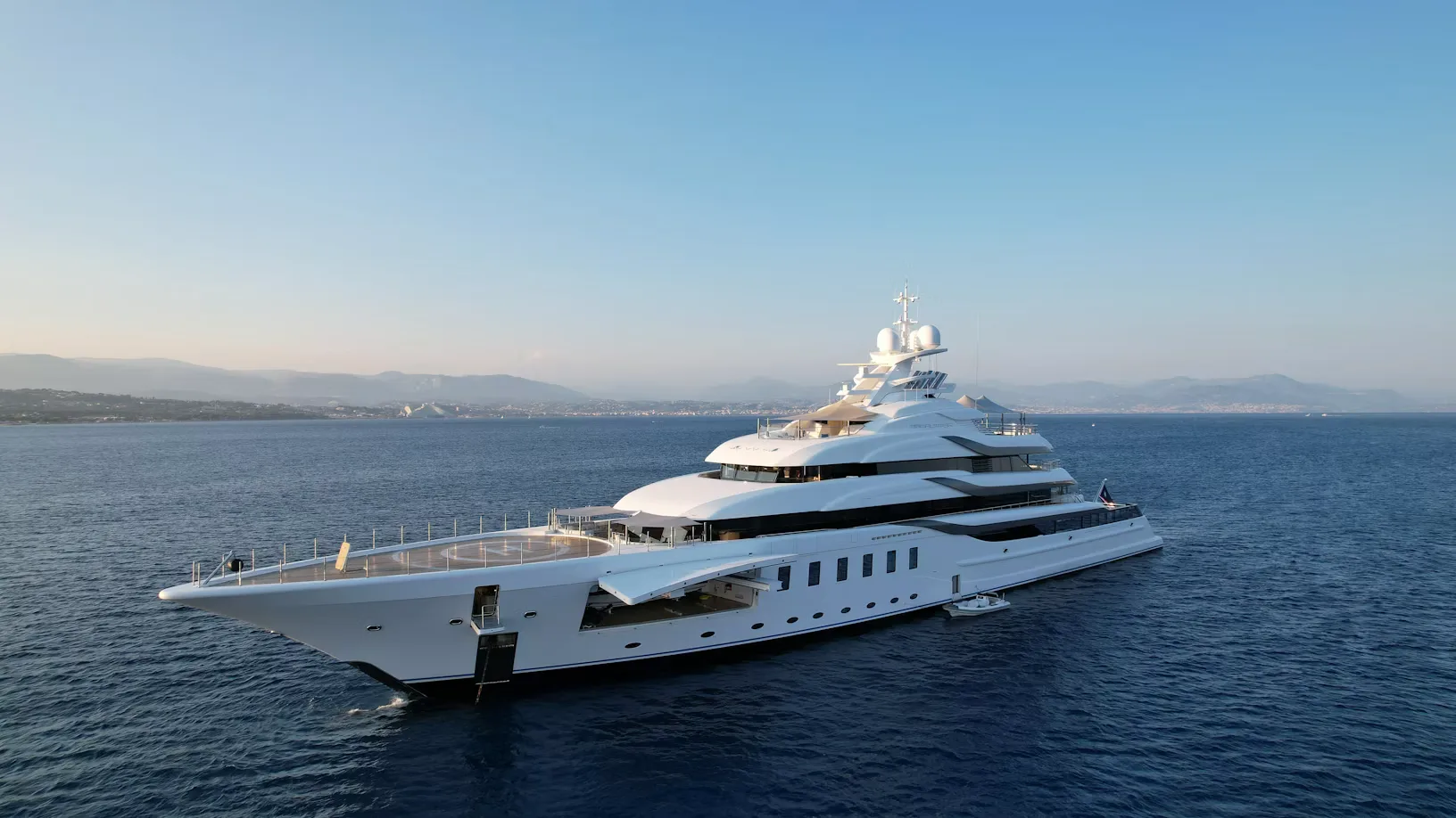 White superyacht at anchor on calm blue water